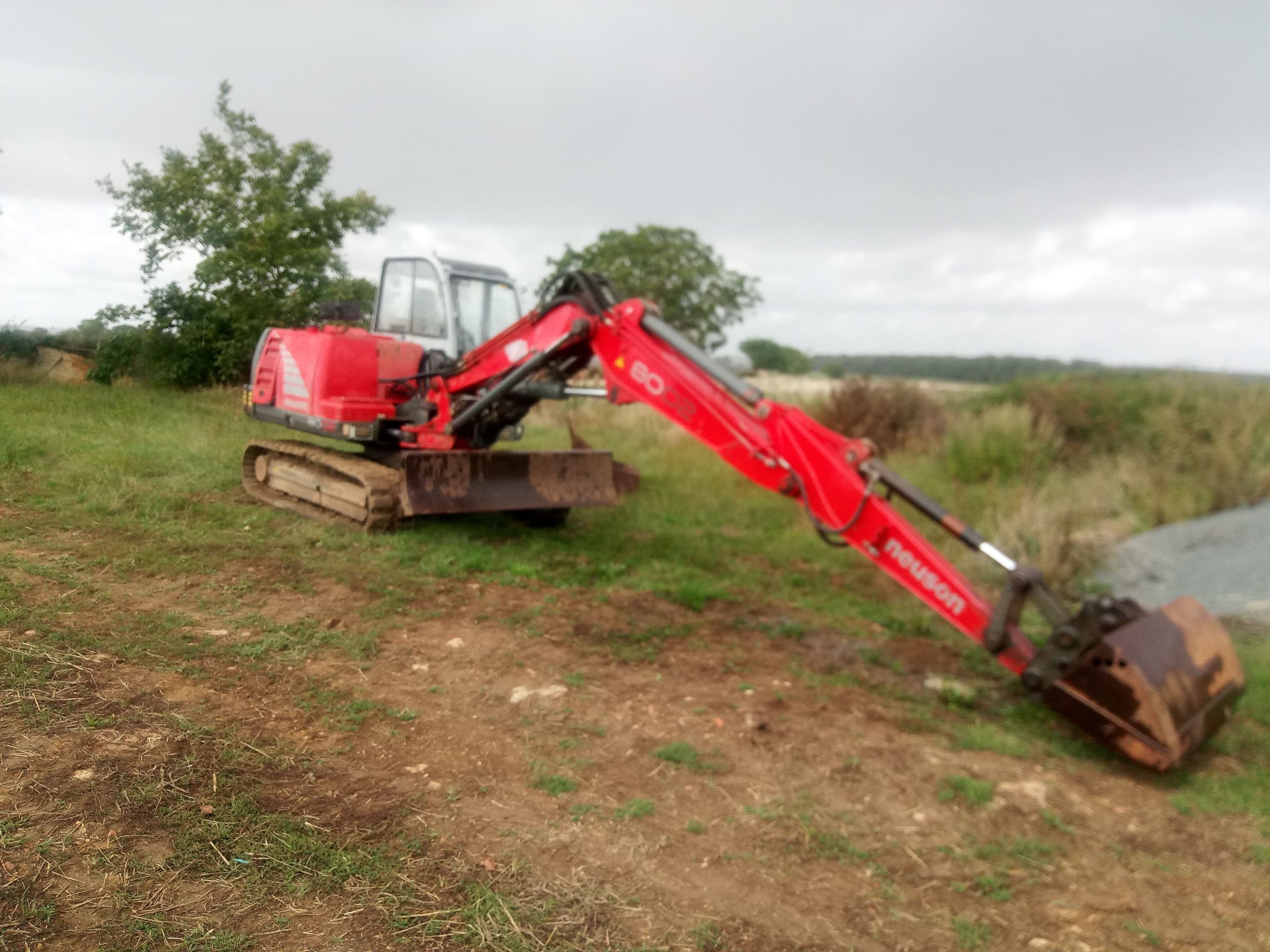 tractopelle rouge dans la rubrique contact